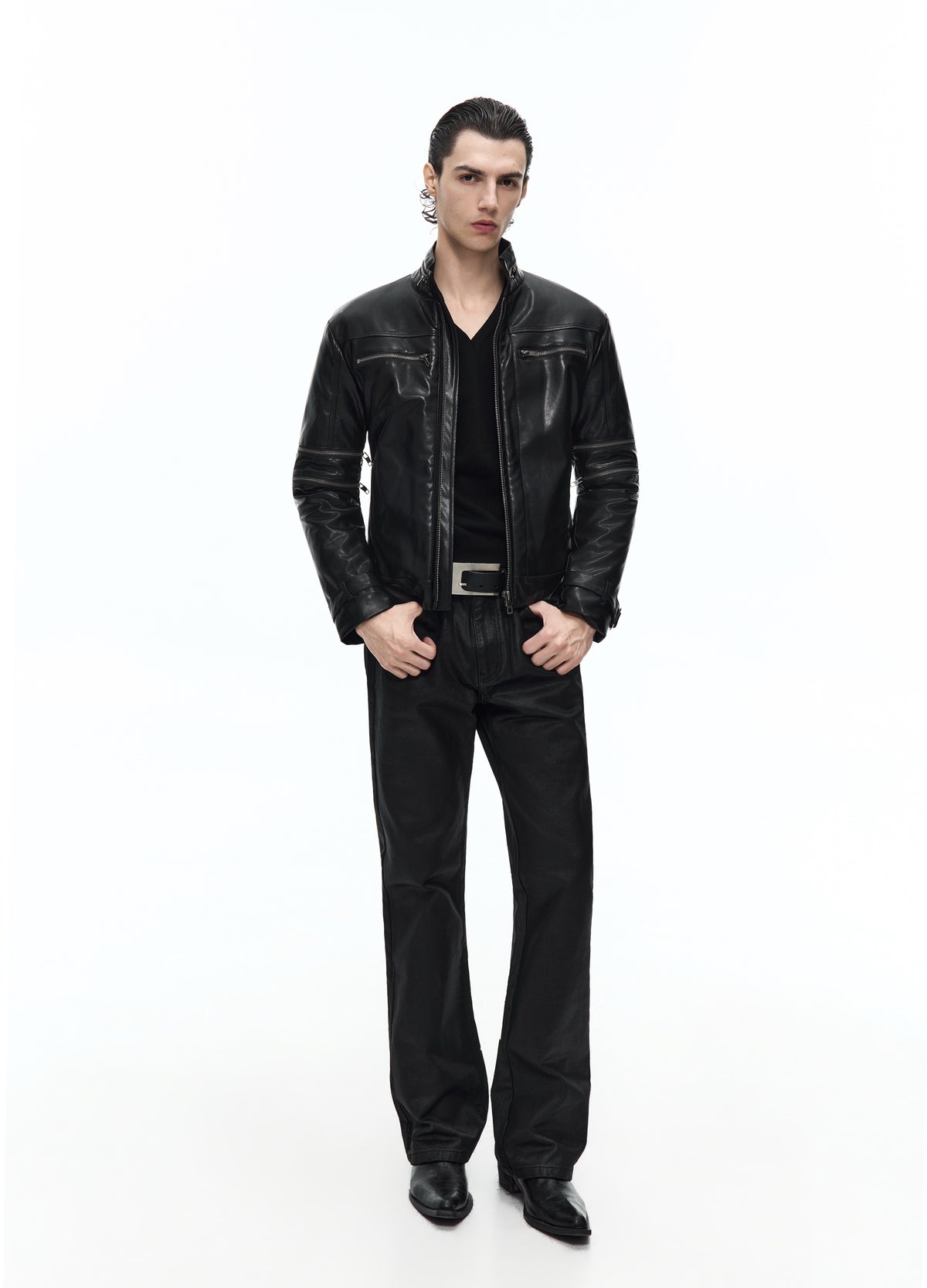 Front view of a model in a shiny black jacket with a short stand collar and horizontal chest zips, worn open over a black V-neck top.