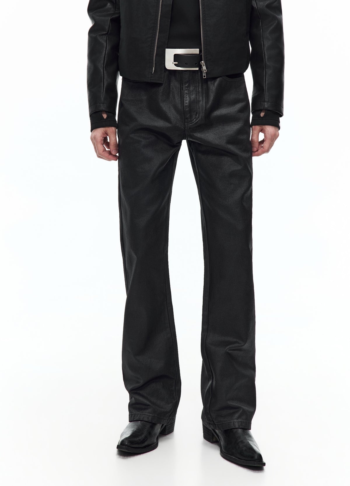 Front view of black trousers from the waist to the shoes, showing a glossy finish, slim upper legs and slightly flared hems.