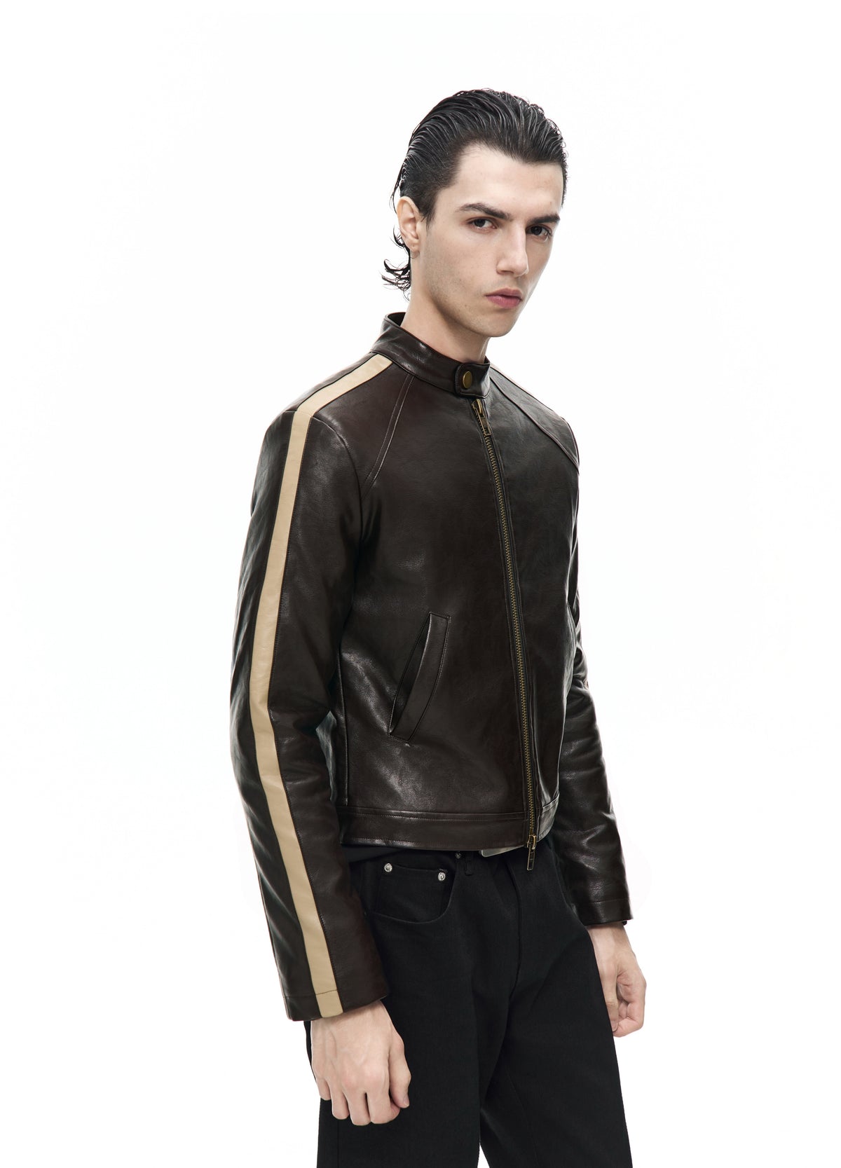 Closer three-quarter view of the zipped dark brown jacket, showing the stand collar, slanted pocket and pale sleeve stripe.