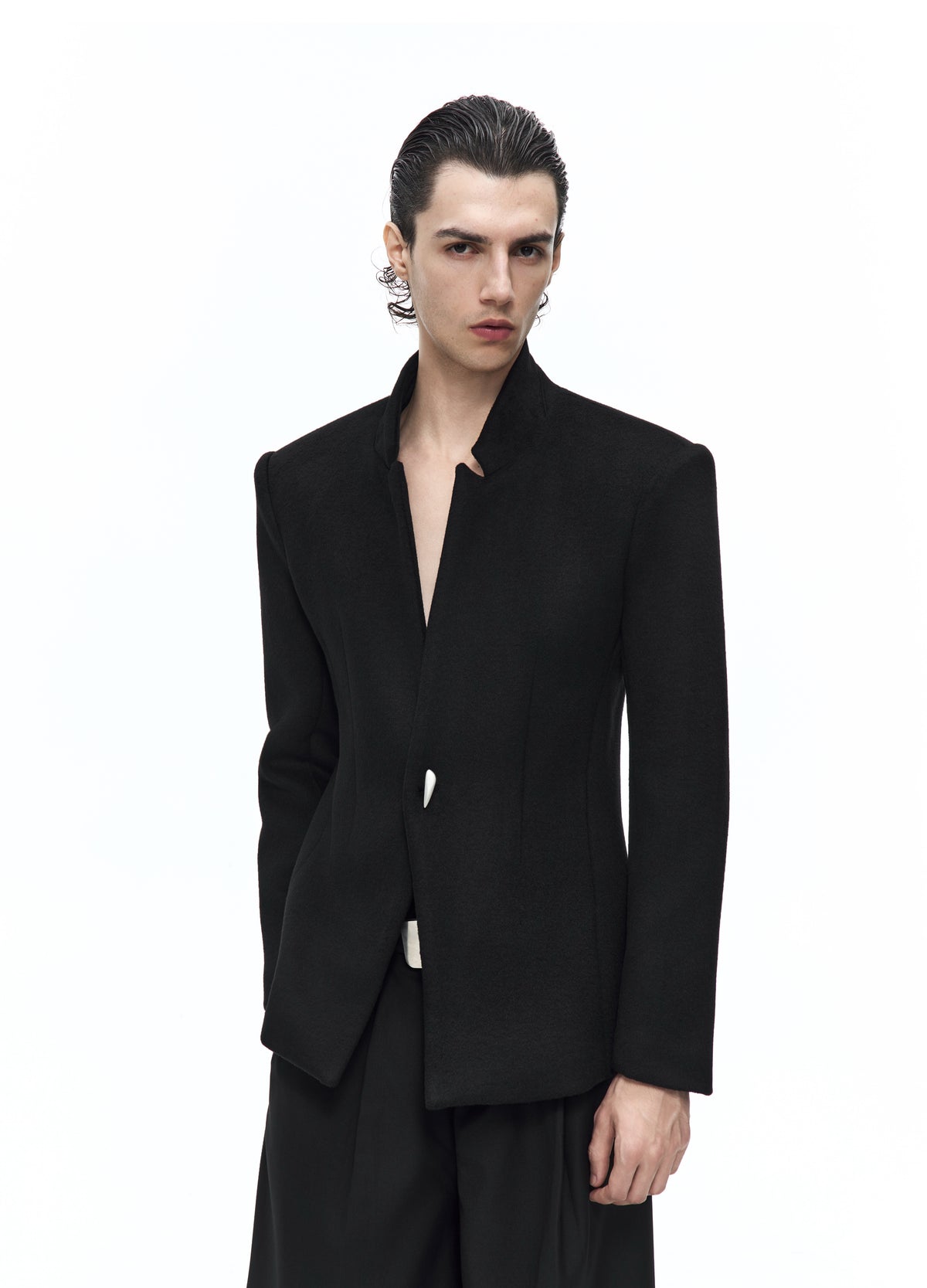 Closer front view of the black jacket, showing its high notched collar, deep front opening, fitted waist and silver-tone fastening.