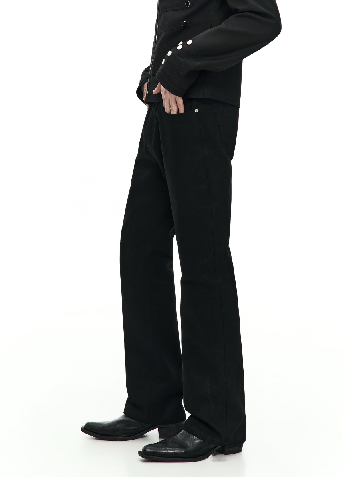 Side view of straight black jeans from the waist to the shoes, showing the side seam and the leg opening over a black shoe.