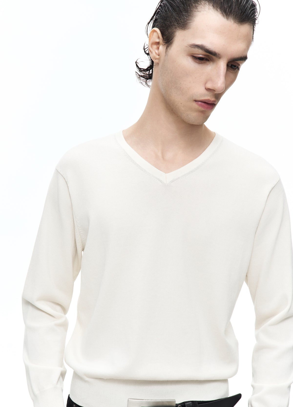 Close view of the off-white top, showing the V-shaped neckline, shoulder seams and long sleeves.