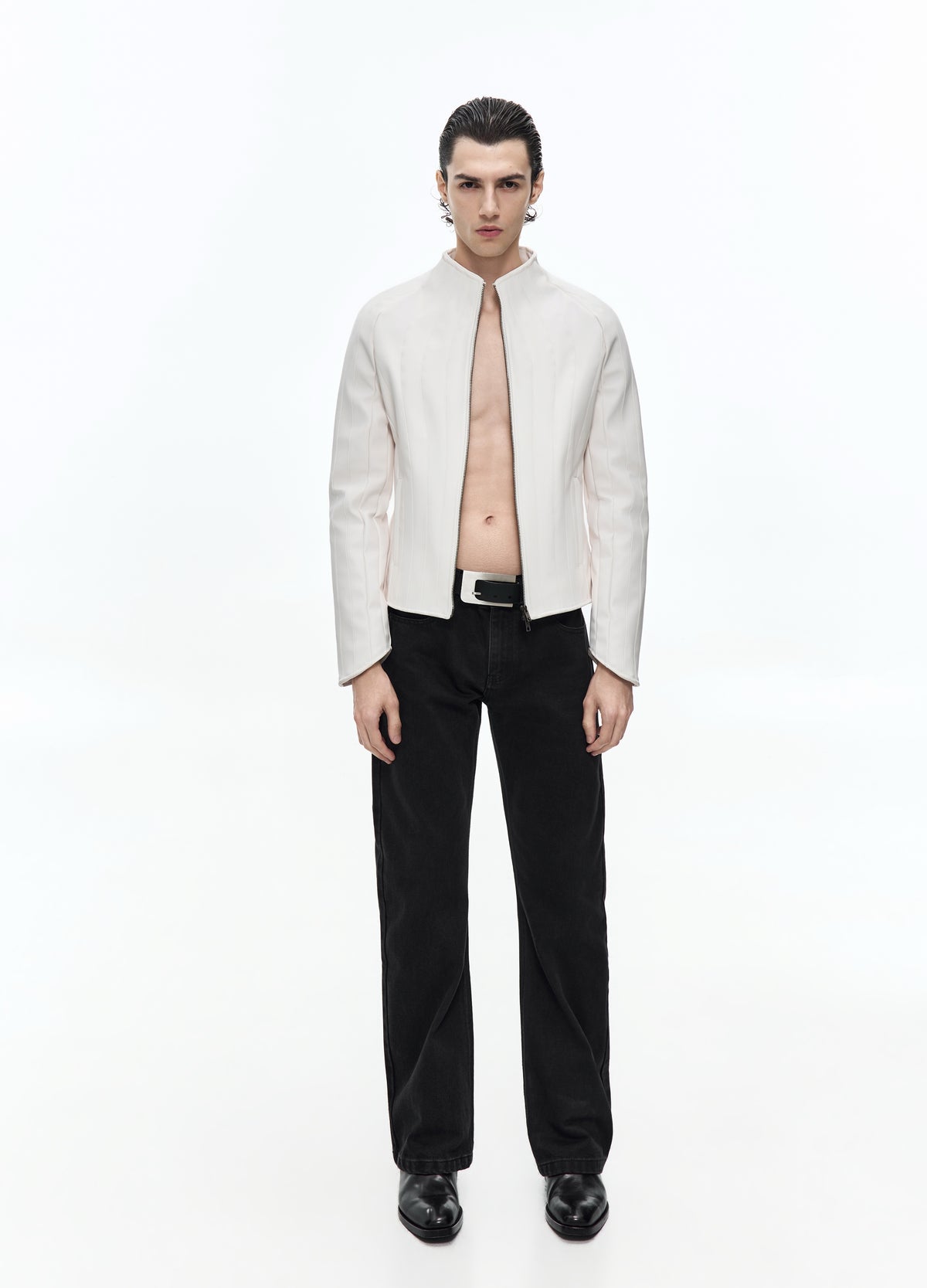 Front view of a model in an off-white jacket worn open, showing the stand collar and shaped vertical panels above black trousers.