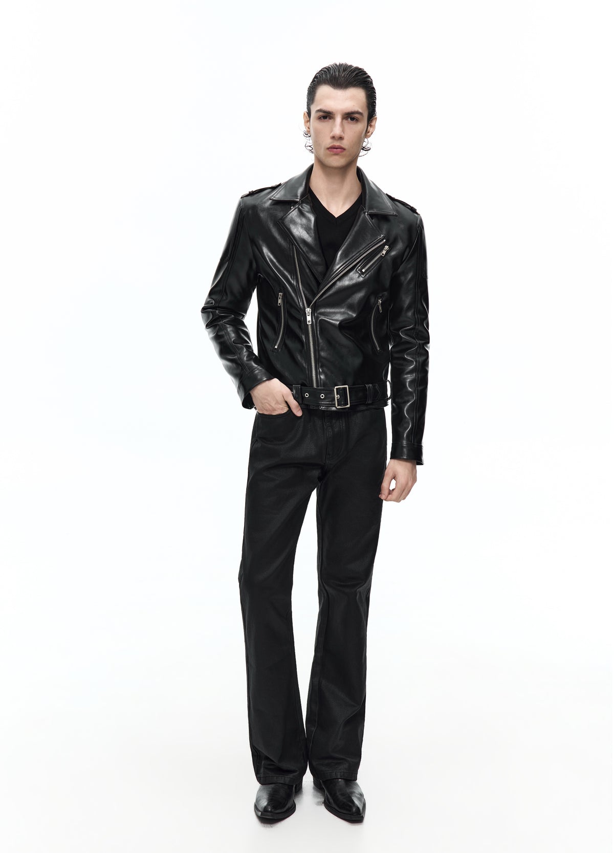 Front view of the black biker jacket zipped across the body, with wide lapels, a buckled waist belt and black trousers.