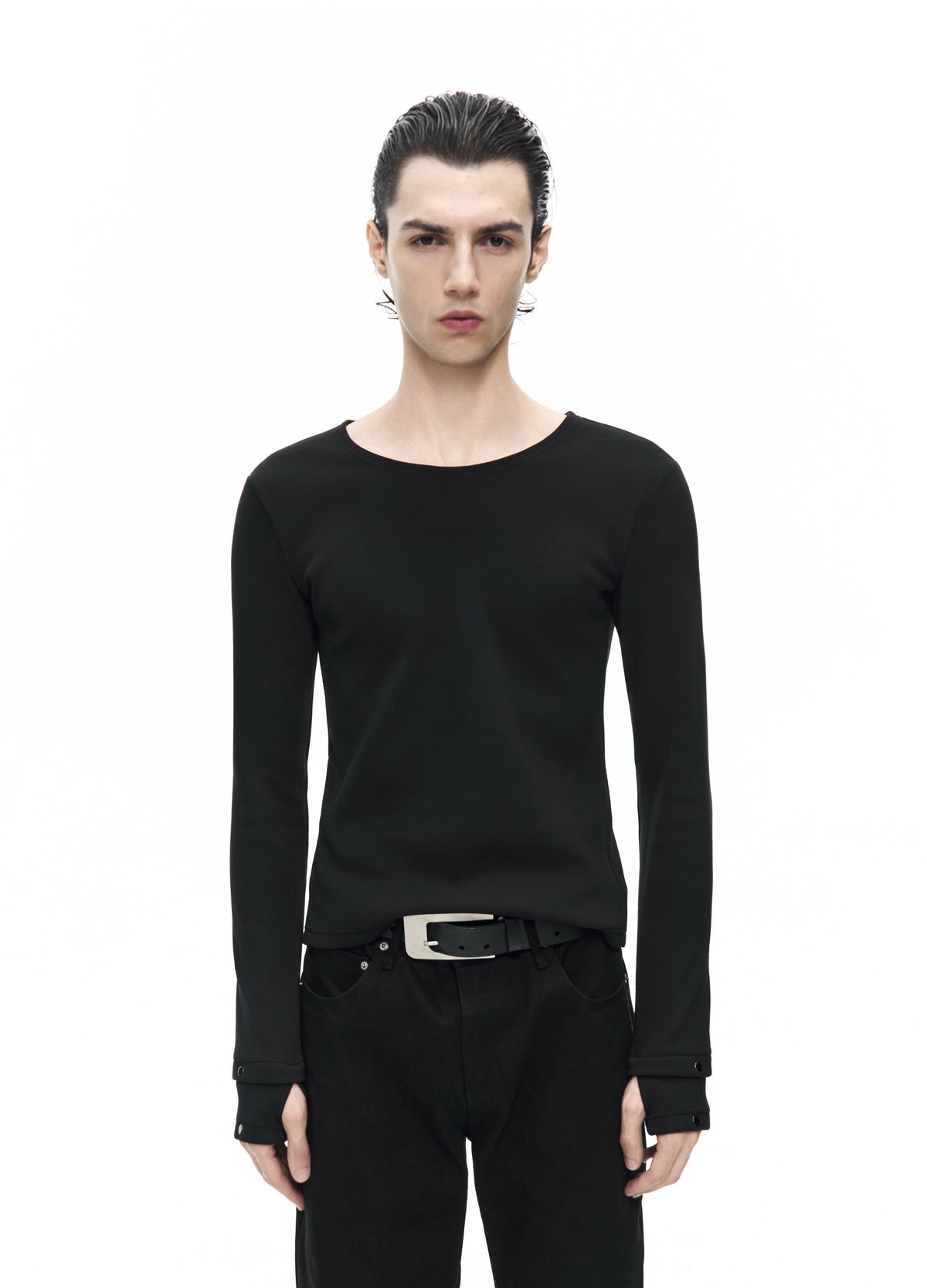 Closer front view of the black round-neck top, showing its fitted waist and long cuffs extending over the hands.