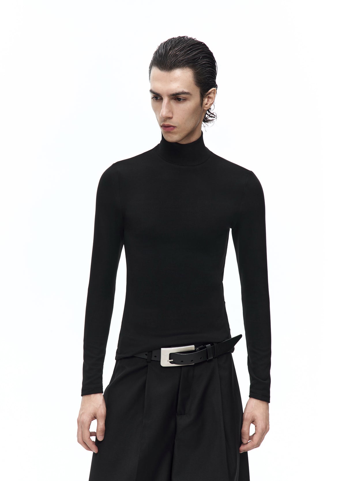 Closer front view of the black high-neck top, showing the close fit through the shoulders, sleeves and waist above a silver-tone belt buckle.