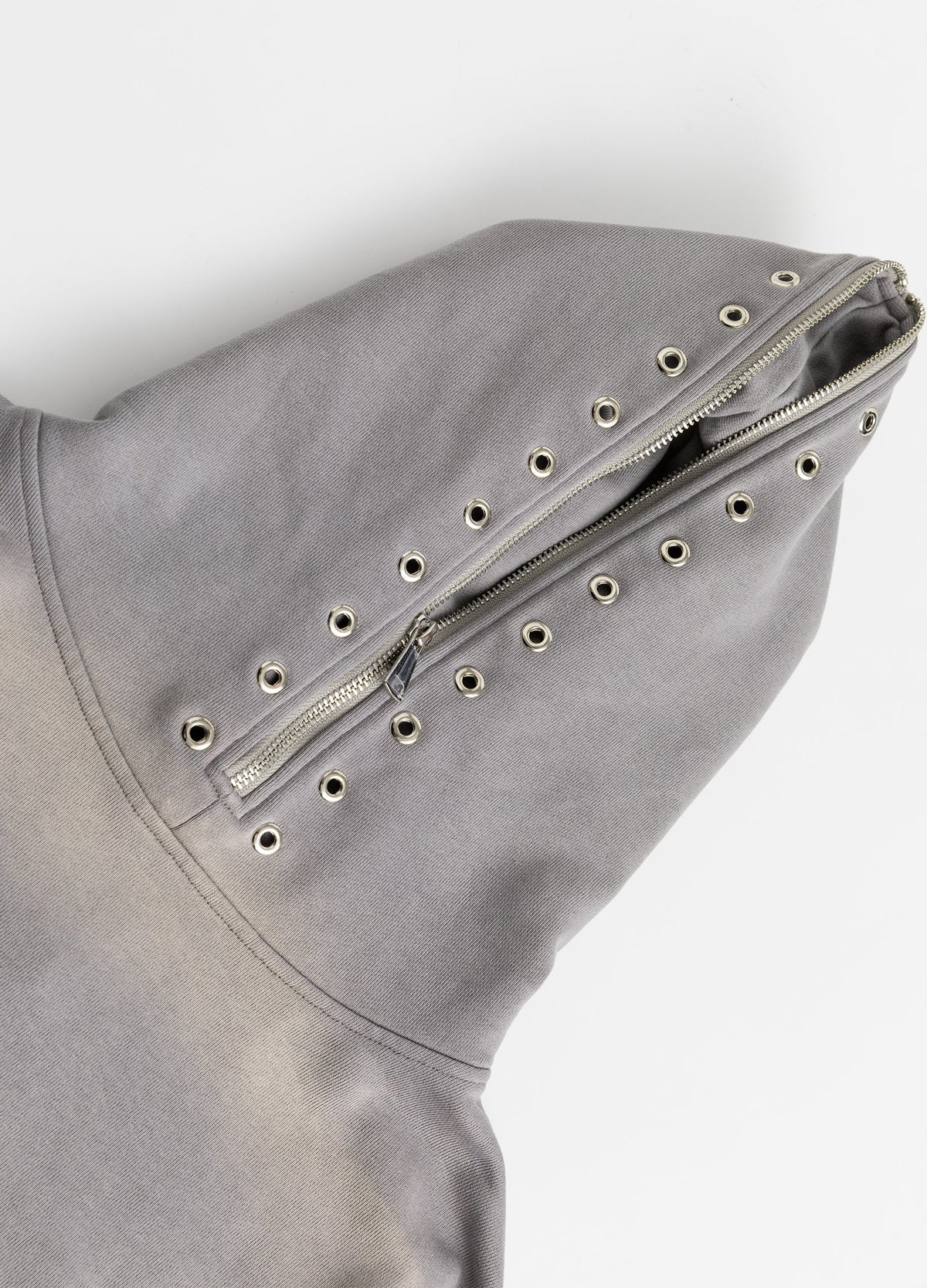 Hood zip bordered by metal eyelets.