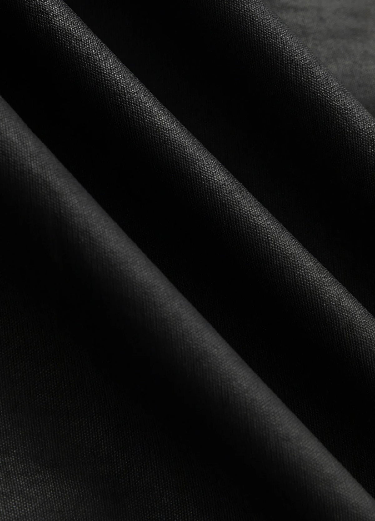 Dark mottled fabric surface.