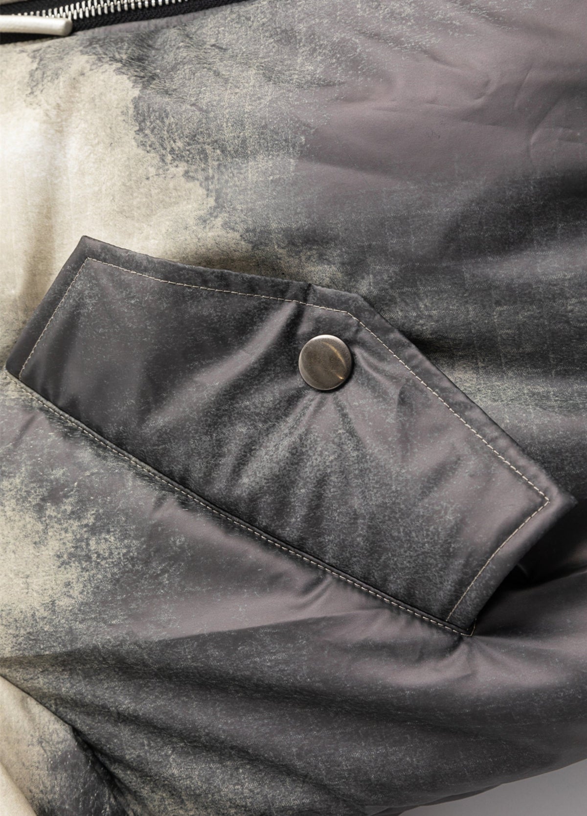 Snap-fastened pocket and mottled surface.