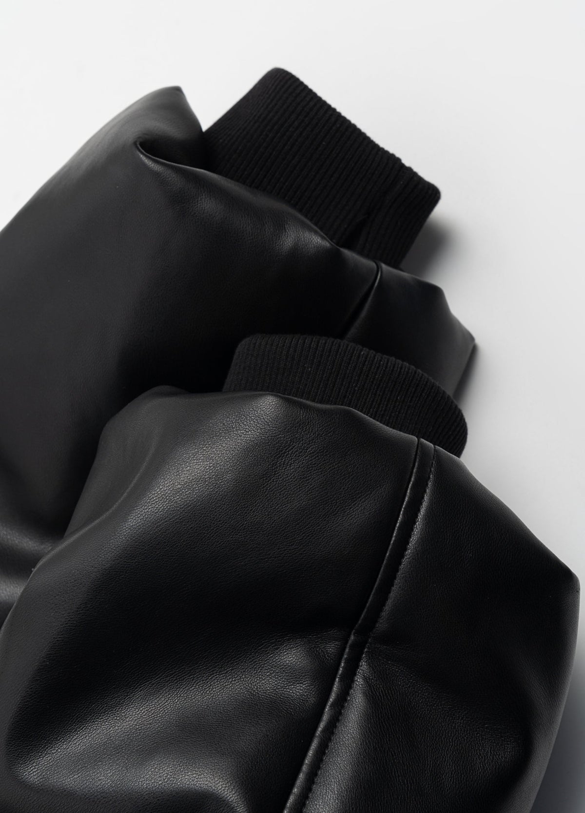 Rib-knit cuffs and glossy sleeve surface.