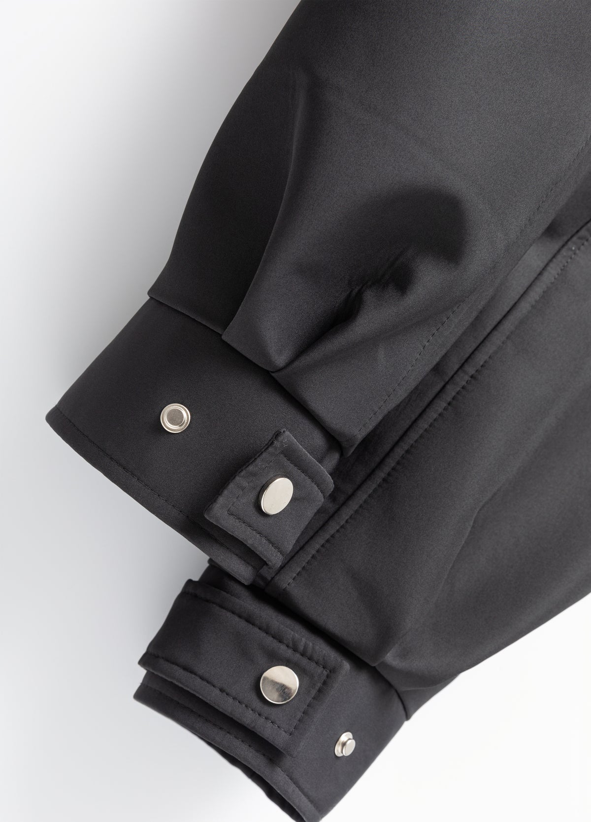 Cuff tabs with press studs.