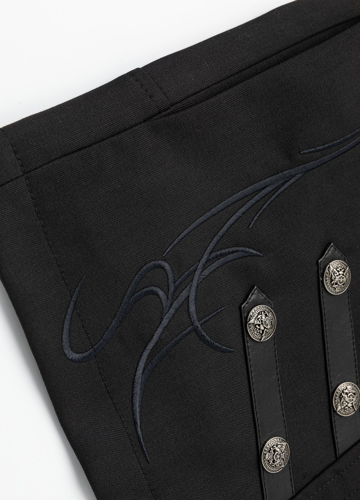 Embroidered motif with decorative buttons.