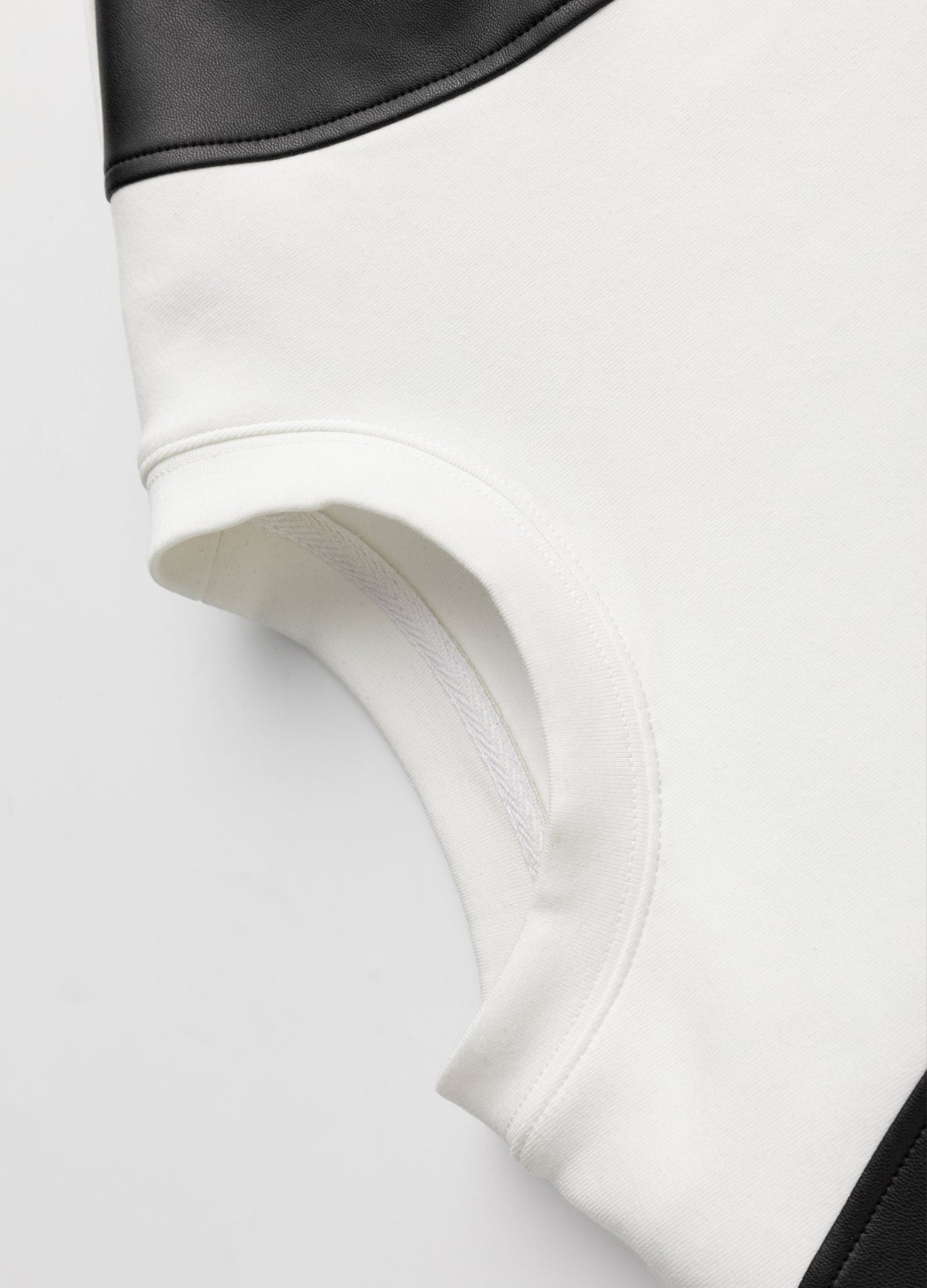 White neckline with contrasting curved black panel.