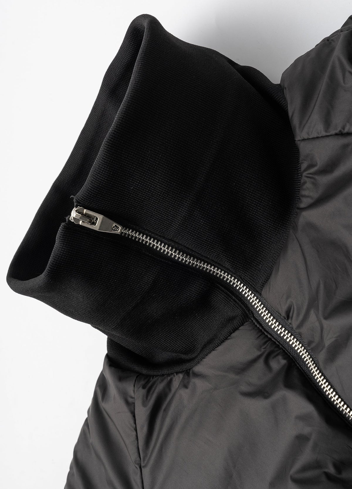 Ribbed high collar and metal zip.