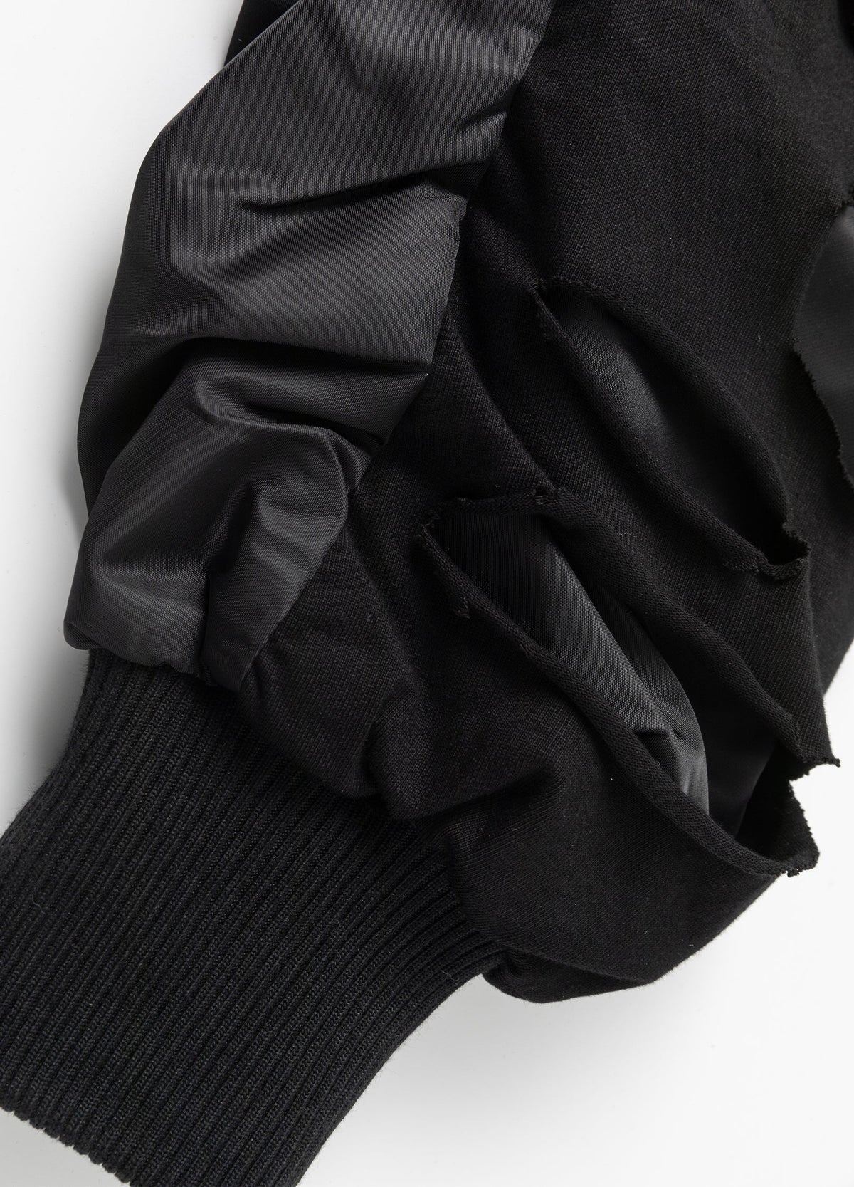 Cutout sleeve overlay and rib-knit cuff.