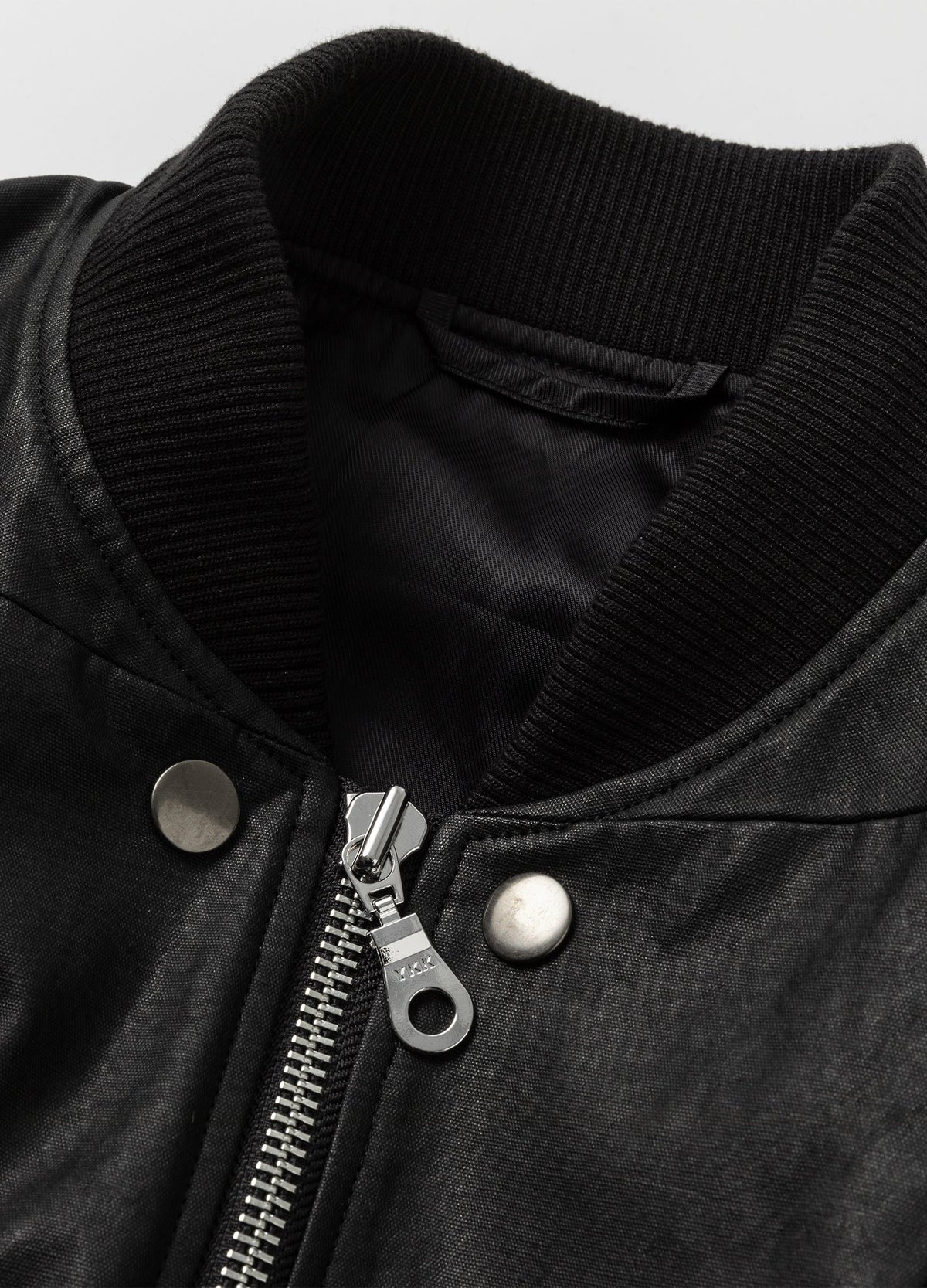 Ribbed collar, metal zip and snap details.