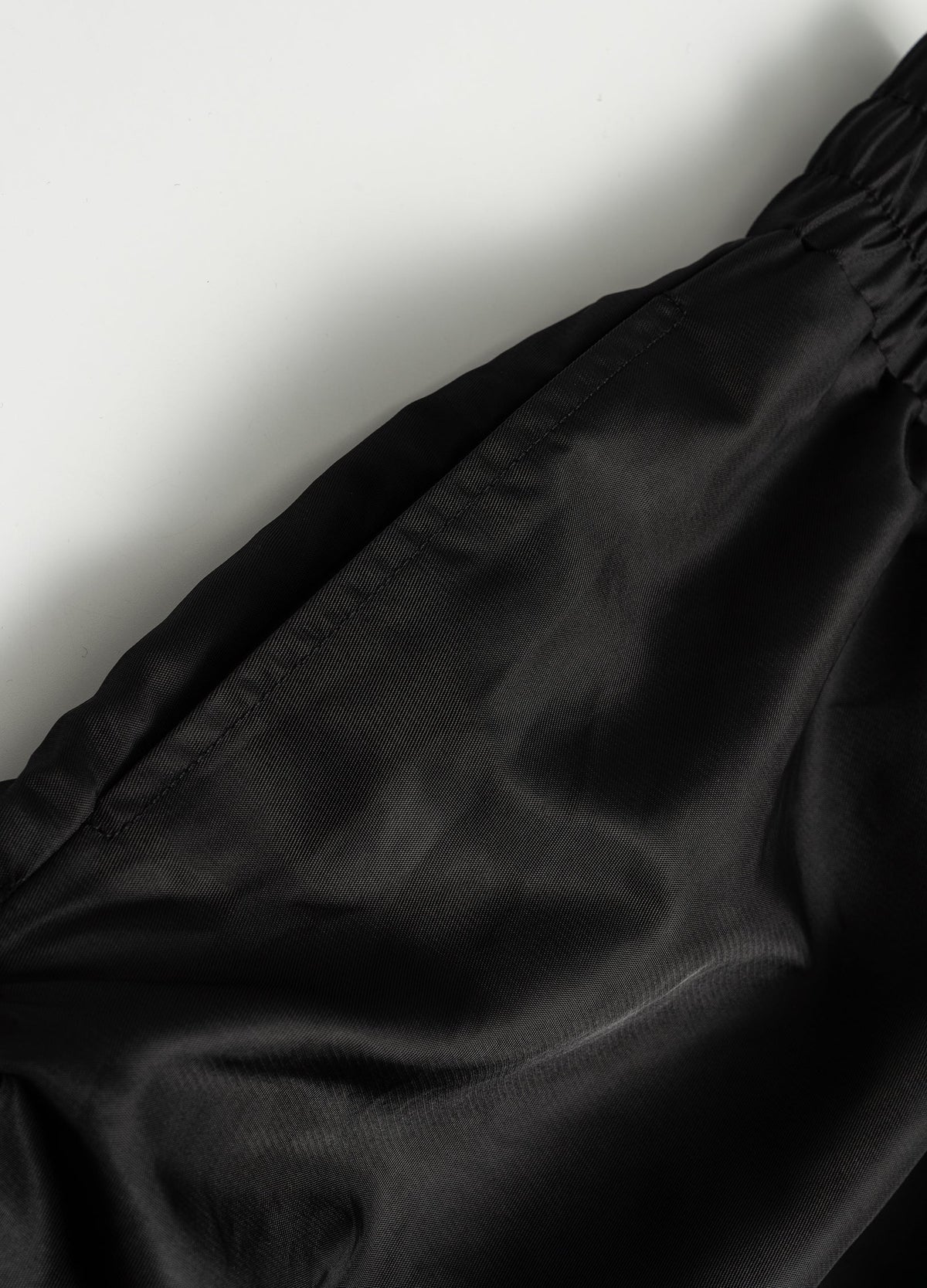 Side pocket opening and stitched edge.
